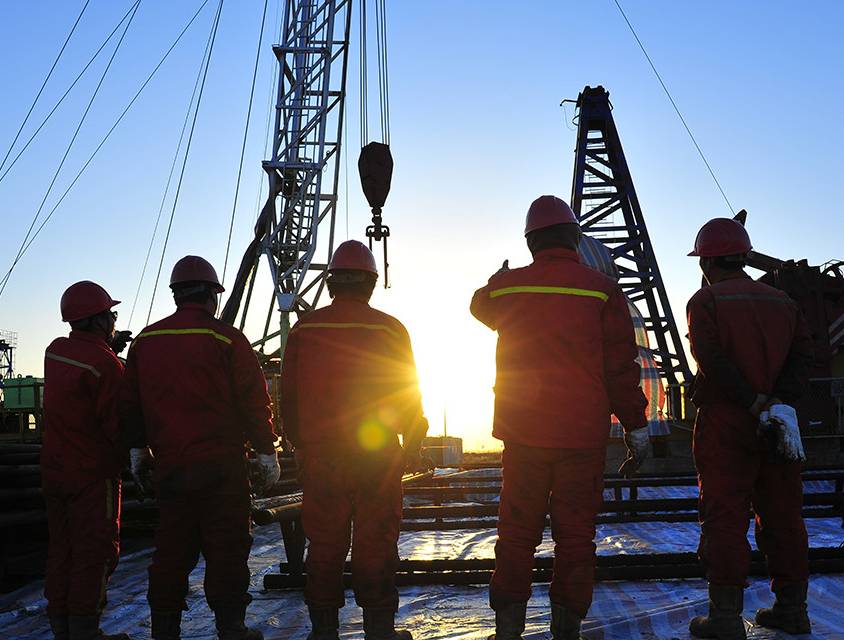 Oil Rig Workers At Sunset